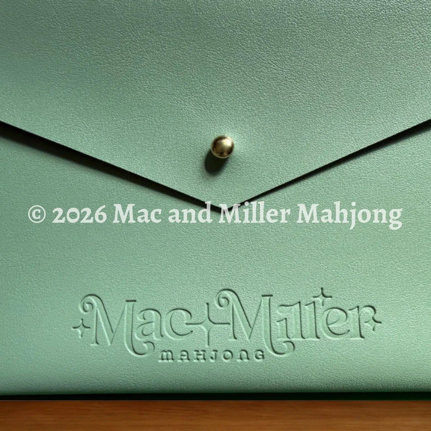 Sage leather card clutch with 'Mac Miller' logo embossed 